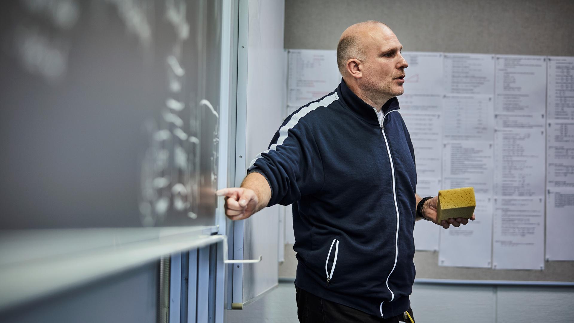Underviser står ved tavle
